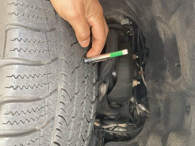 Technician measuring tire tread depth